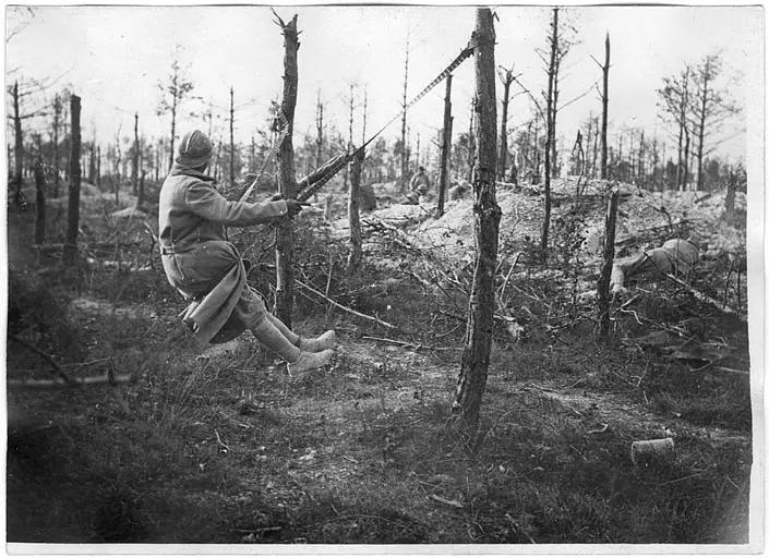 Bois de Beine : poilus improvisant une balançoire avec une bande de mitrailleuse allemande